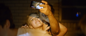 A couple takes a selfie at night in warm light